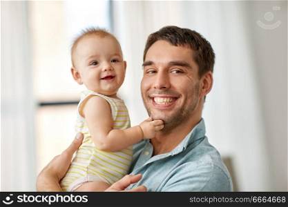 family, fatherhood and people concept - happy father holding little baby daughter at home. happy father holding little baby daughter at home