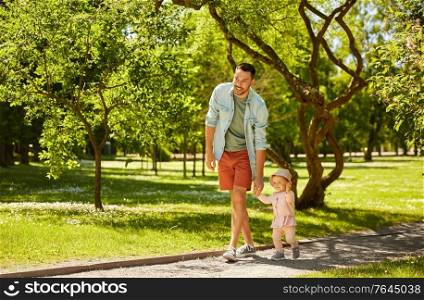 family, fatherhood and people concept - happy father with baby daughter at summer park. happy father with baby daughter at summer park