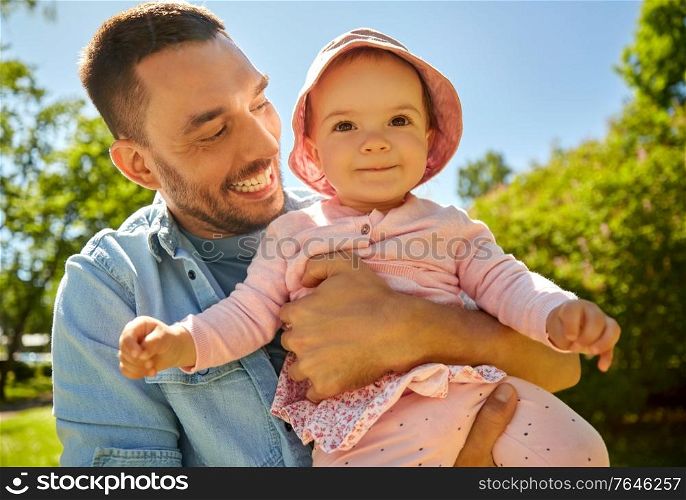 family, fatherhood and people concept - happy father with baby daughter at summer park. happy father with baby daughter at summer park