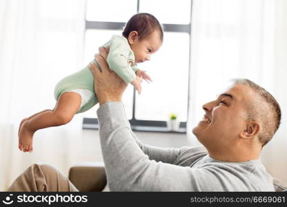 family, fatherhood and people concept - happy father with little baby boy sitting on sofa at home. happy father with little baby boy at home. happy father with little baby boy at home