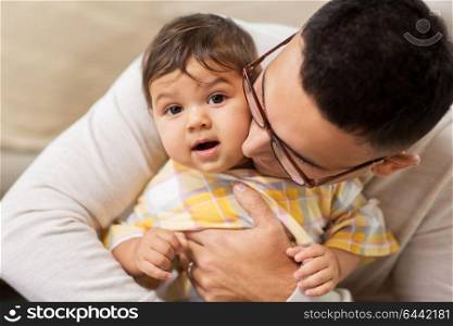 family, fatherhood and people concept - happy father with little baby daughter at home. happy father with little baby daughter at home