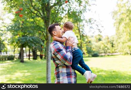 family, fatherhood and people concept - happy father with little son in summer park. happy father with little son in summer park