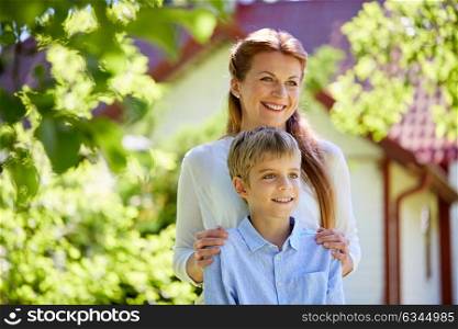 family, fatherhood and people concept - happy mother and son at summer garden. happy mother and son at summer garden