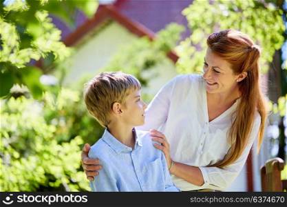 family, fatherhood and people concept - happy mother and son at summer garden. happy mother and son at summer garden