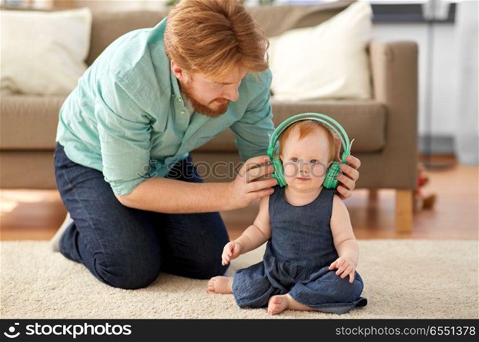 family, fatherhood and people concept - happy red haired father with little baby daughter at home. happy father with little baby daughter at home. happy father with little baby daughter at home