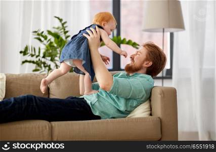 family, fatherhood and people concept - happy red haired father with little baby girl at home. happy father with little baby girl at home. happy father with little baby girl at home