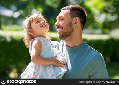 family, fatherhood and people concept - happy smiling father with baby daughter at summer park. happy father with baby daughter at summer park