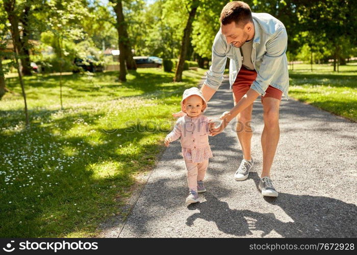 family, fatherhood and people concept - happy smiling father with baby daughter walking at summer park. happy father with baby daughter walking at park