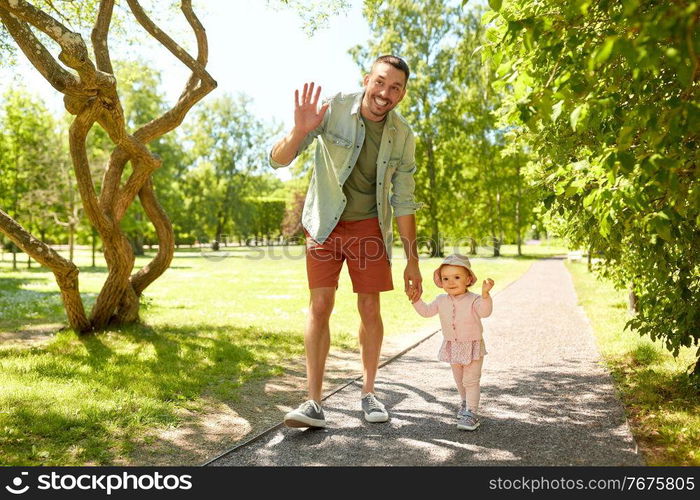 family, fatherhood and people concept - happy smiling father with baby daughter walking at summer park. happy father with baby daughter walking at park