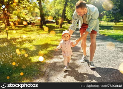 family, fatherhood and people concept - happy smiling father with baby daughter walking at summer park. happy father with baby daughter walking at park