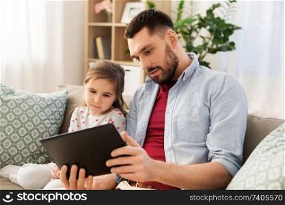family, fatherhood and technology concept - father and little daughter with tablet pc computer at home. father and daughter with tablet computer at home