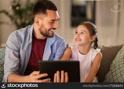 family, fatherhood and technology concept - happy father and little daughter with tablet pc computer at home. father and daughter with tablet computer at home