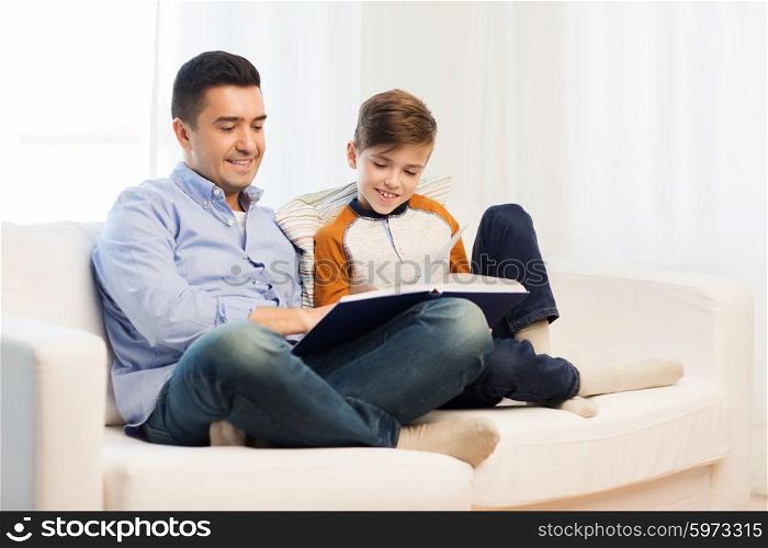 family, fatherhood, generation, literature and people concept - happy father and son reading book at home