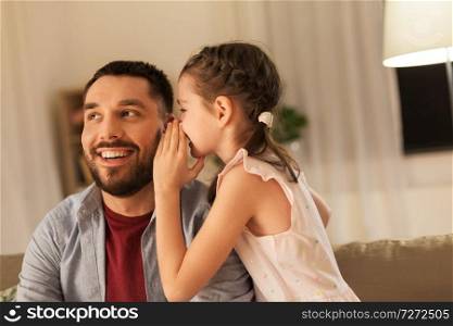 family, fatherhood, leisure and people concept - happy daughter whispering secret to father at home. happy daughter whispering secret to father at home