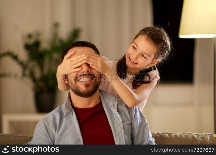 family, fatherhood, leisure and people concept - happy smiling father and little daughter playing at home in evening. happy father and little daughter playing at home