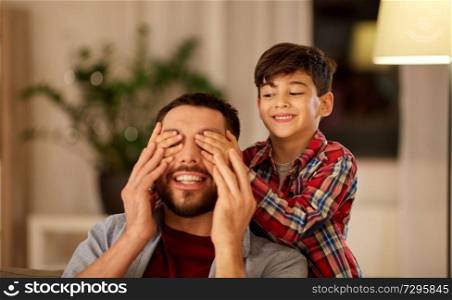 family, fatherhood, leisure and people concept - happy smiling father and little son playing at home. happy father and little son playing at home