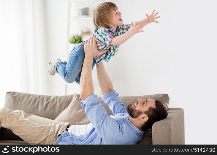 family, fatherhood, people and parenthood concept - happy smiling young father with little son at home. happy young father playing with little son at home