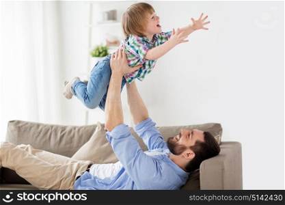 family, fatherhood, people and parenthood concept - happy smiling young father with little son at home. happy young father playing with little son at home