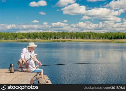 family fishing on a beautiful lake with fishing rods