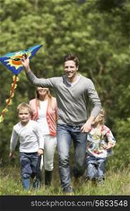 Family Flying Kite In Countryside