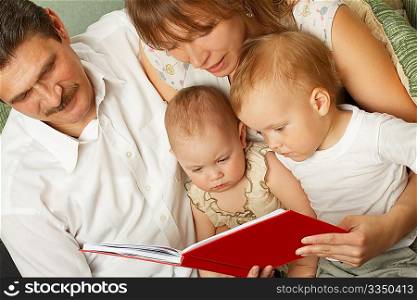 Family from four person in common read the children&acute;s book