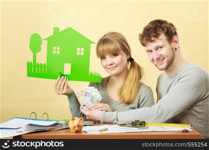 Family future ownership financial bank property home concept. Young couple managing finances. Girl and boy counting money showing house symbol.. Young couple managing finances.