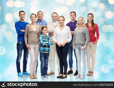 family, gender, generation and people concept - group of smiling men, women and boy over blue holidays lights background