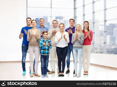 family, gender, generation and people concept - group of smiling men, women and boy applauding over empty office room or home