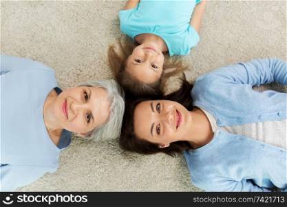 family, generation and female concept - mother, daughter and grandmother lying on floor from top. mother, daughter and grandmother lying on floor