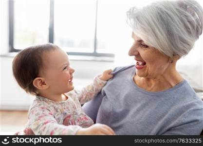 family, generation and happiness concept - happy smiling grandmother with baby granddaughter at home. happy grandmother with baby granddaughter at home