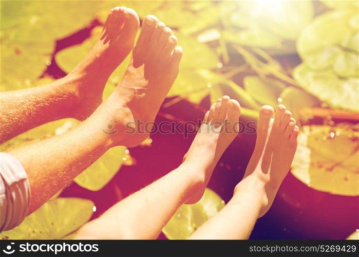 family, generation and people concept - grandfather and grandson feet over river. grandfather and grandson feet over river
