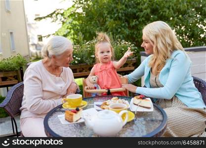 family, generation and people concept - happy mother, daughter and grandmother at cafe or restaurant terrace. mother, daughter and grandmother at cafe