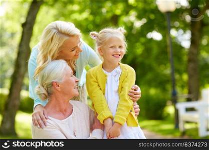 family, generation and people concept - happy smiling mother, daughter and grandmother at park. happy mother, daughter and grandmother at park