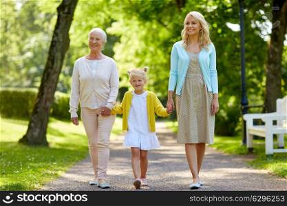 family, generation and people concept - happy smiling mother, daughter and grandmother walking at park. happy mother, daughter and grandmother at park