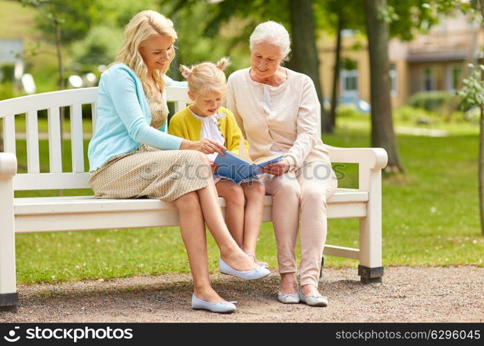 family, generation and people concept - happy smiling woman with daughter and senior mother sitting on park bench. woman with daughter and senior mother at park