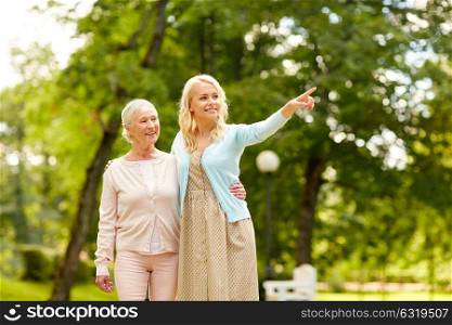 family, generation and people concept - happy smiling young daughter with senior mother at park. daughter with senior mother at park