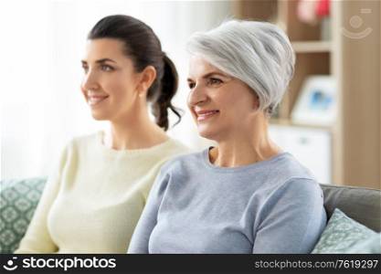 family, generation and people concept - portrait of happy smiling senior mother with adult daughter hugging at home. portrait of old mother and adult daughter at home
