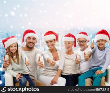 family, generation, gesture, holidays and people concept - happy family in santa helper hats showing thumbs up over snowy city background