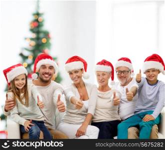 family, generation, gesture, holidays and people concept - happy family in santa helper hats showing thumbs up over living room and christmas tree lights background