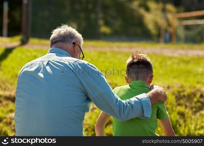 family, generation, relations and people concept - grandfather and grandson hugging outdoors. grandfather and grandson hugging outdoors