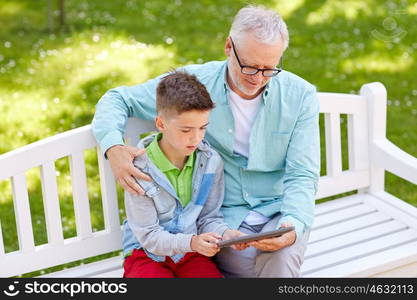 family, generation, technology and people concept - happy grandfather and grandson with tablet pc computer at summer park