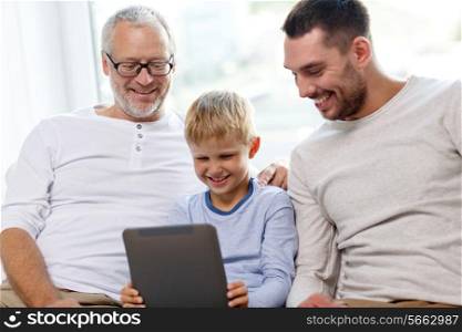 family, generation, technology and people concept - smiling father, son and grandfather sitting on couch with tablet pc computer at home