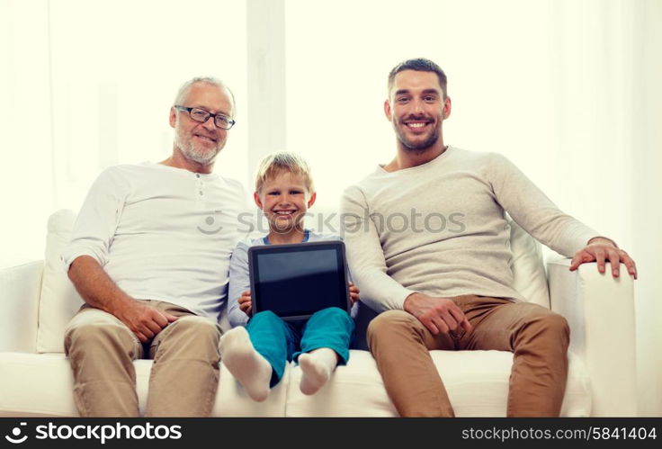 family, generation, technology and people concept - smiling father, son and grandfather sitting on couch with tablet pc computer at home