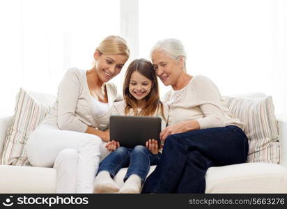 family, generation, technology and people concept - smiling mother, daughter and grandmother with tablet pc computer sitting on couch at home