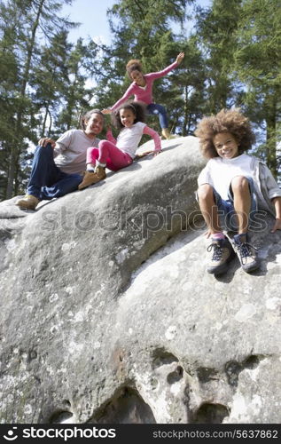 Family Group Sitting On Rock Together