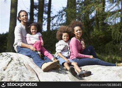 Family Group Sitting On Rock Together
