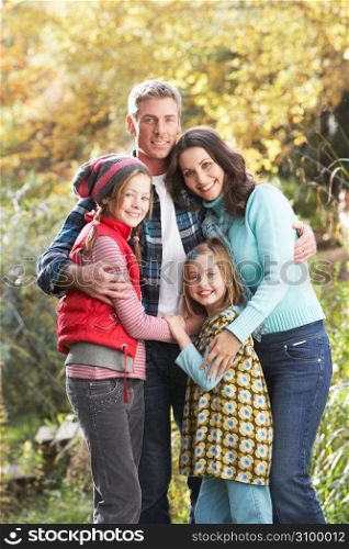 Family Group Standing Outdoors On Wooden Walkway In Autumn Landscape