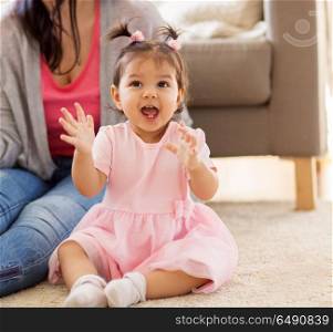 family, happiness and people concept - happy baby girl with mother at home. happy baby girl with mother at home. happy baby girl with mother at home