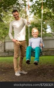 family, happiness, generation, home and people concept - happy father and son swinging on teeterboard outdoors