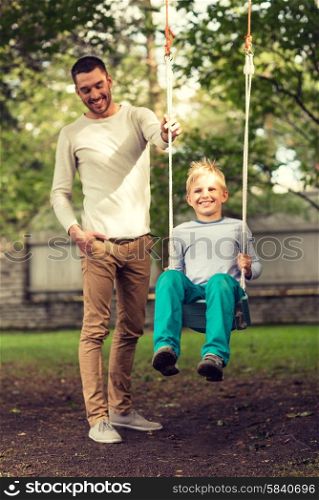family, happiness, generation, home and people concept - happy father and son swinging on teeterboard outdoors